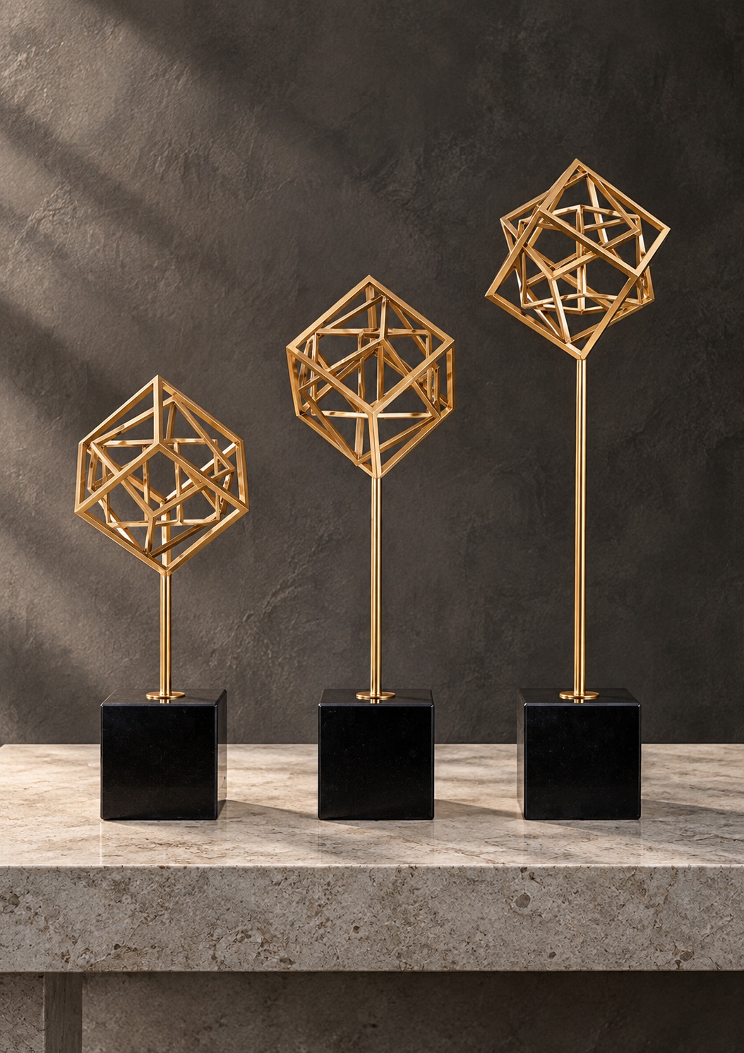 Trio de sculptures géométriques dorées sur socles noirs - vue 3