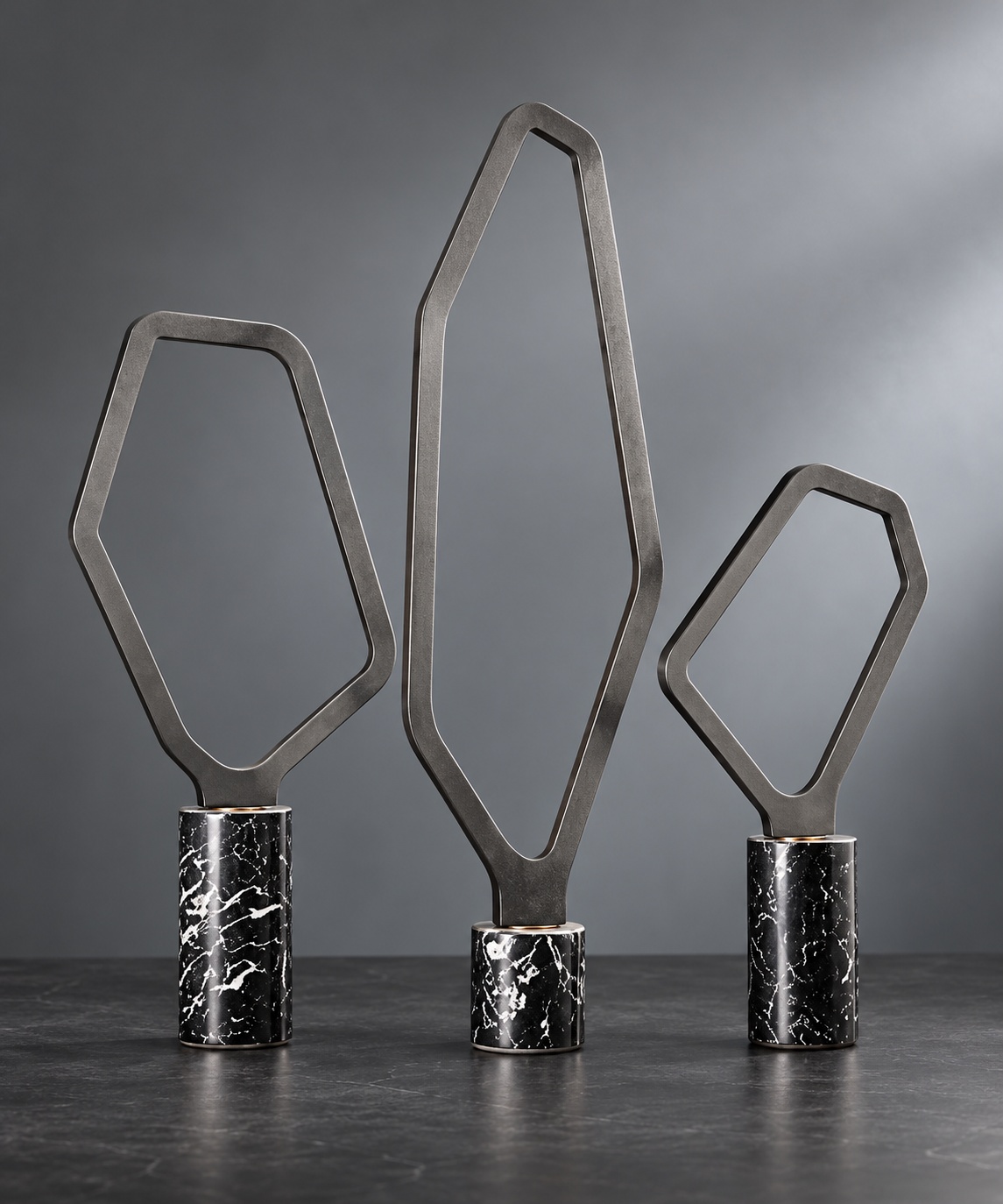 Trio de sculptures géométriques sur socles effet marbre